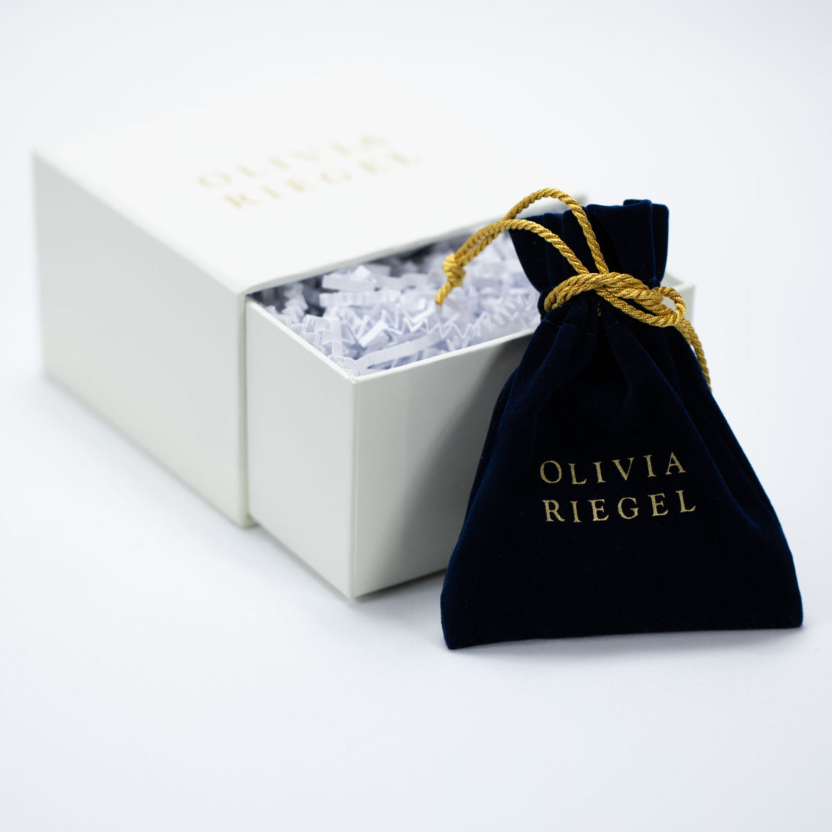 Open white logo gift box with blue jewelry pouch.