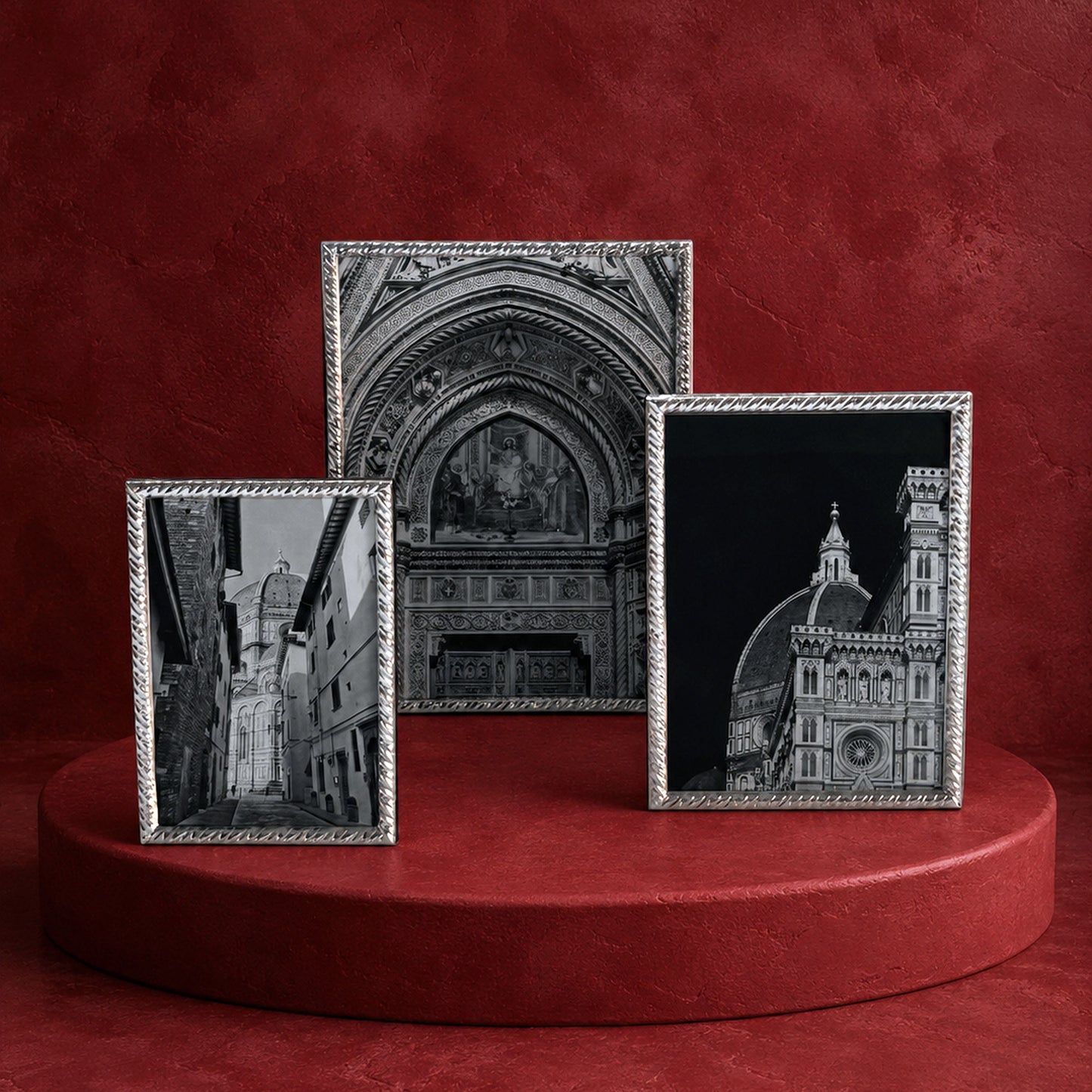 Three Sterling Classic Rope frames displaying black and white architectural photographs, arranged on a round red pedestal against a textured red background.