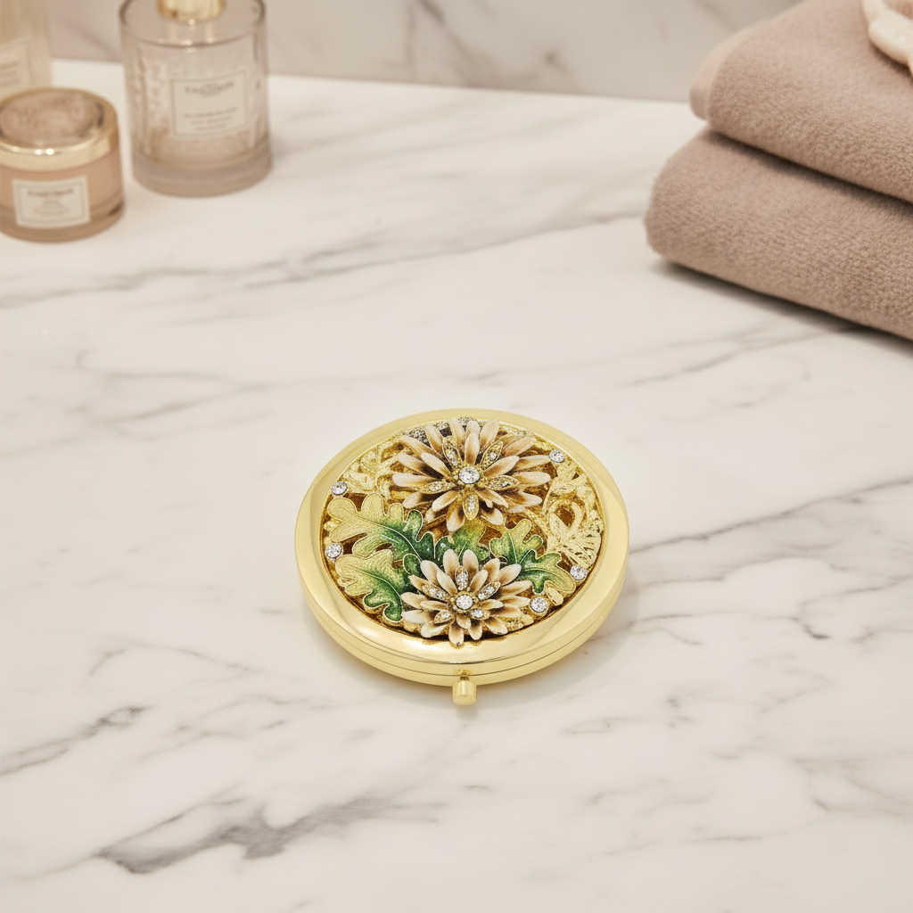 Decorative gold compact mirror with floral design on a marble surface