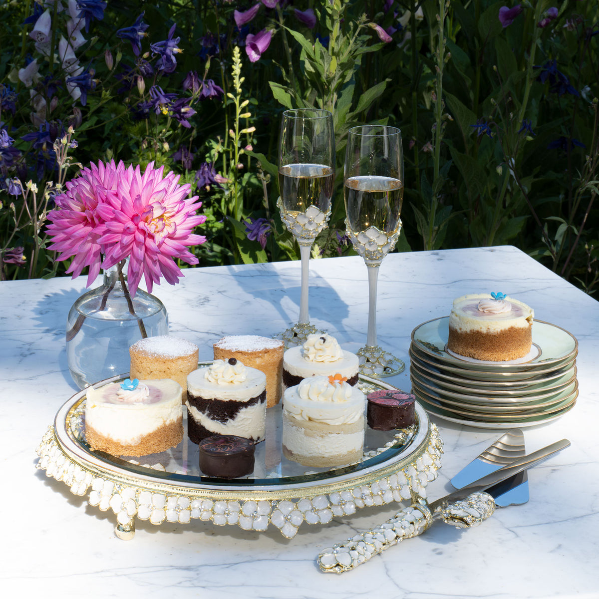 Dogwood Cake Plateau with matching Dogwood Flutes and Dogwood Dessert Serving Set on an outdoor table.