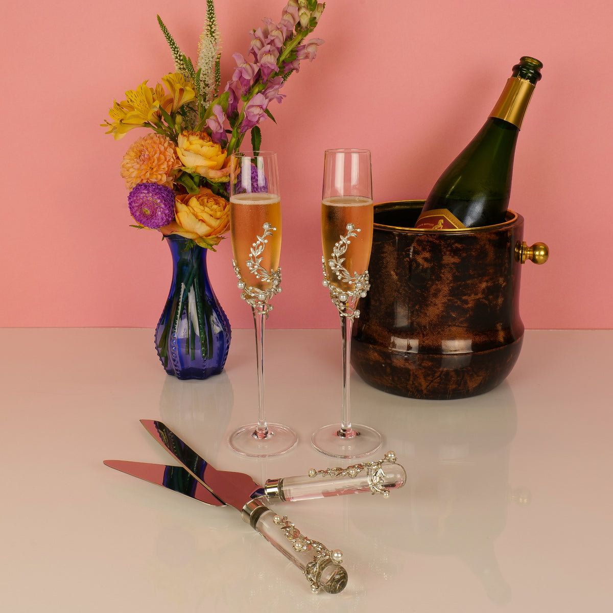 Eleanor Dessert Serving Set with matching Eleanor flutes and an ice bucket with a champagne bottle.